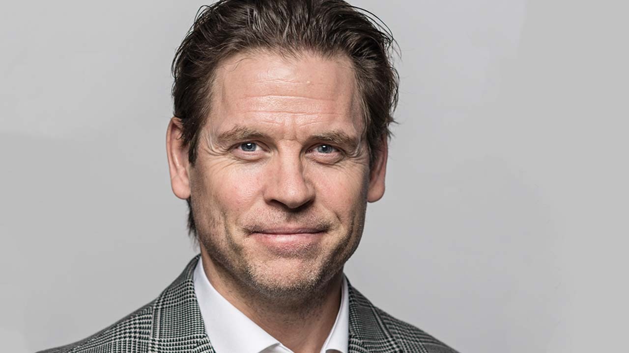 Person iförd rutig kavaj och vit skjorta.