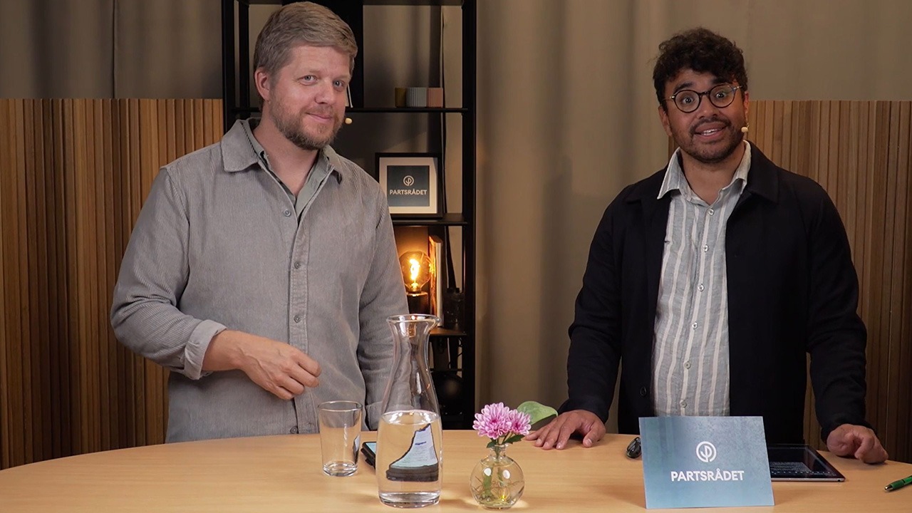 Två personer samtalar i en filmstudio.