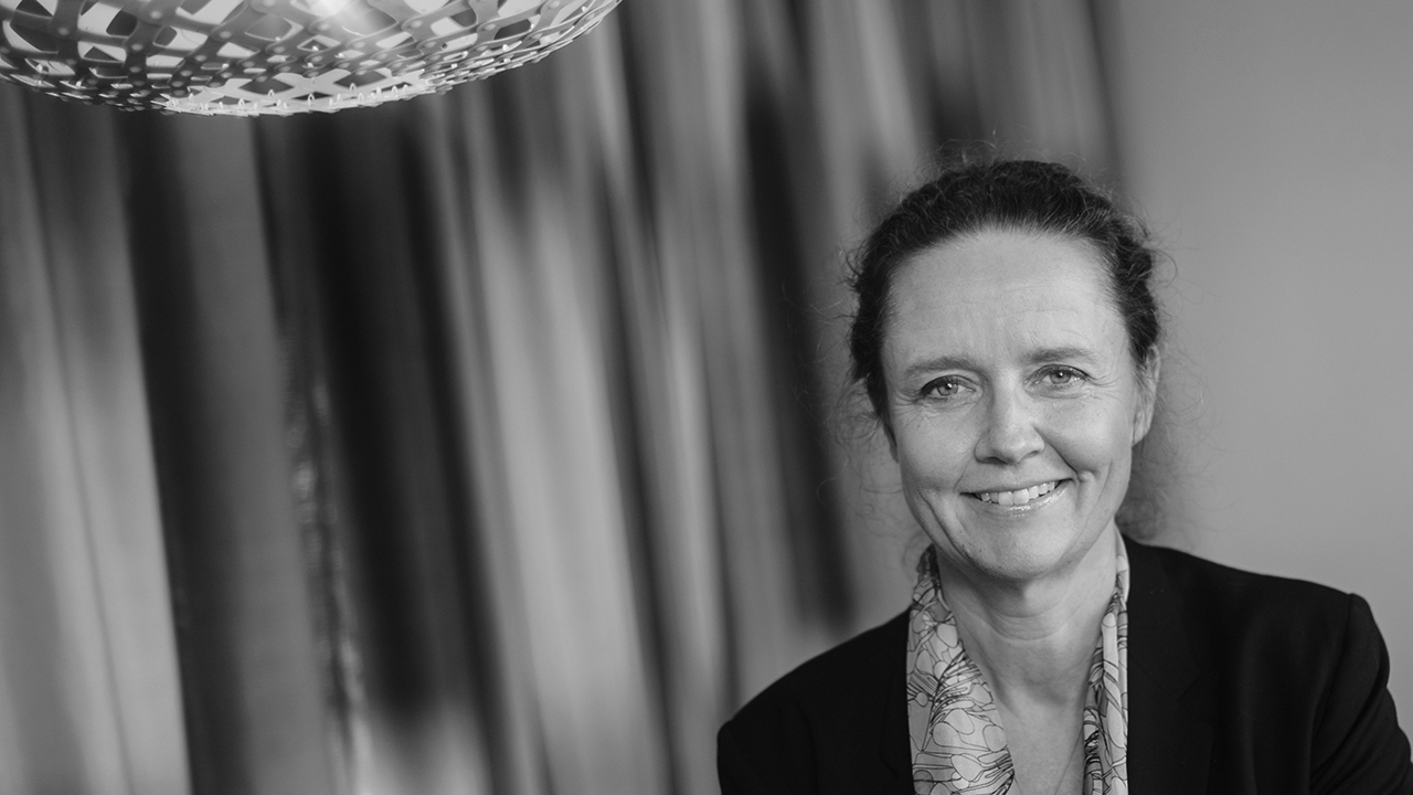Person iförd mörk kavaj och sjal.