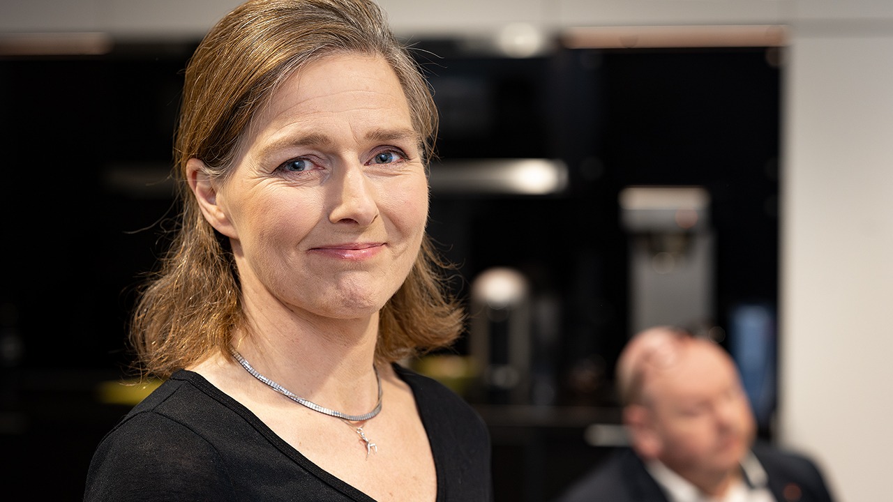 Person iförd svart tröja och silverhalsband.